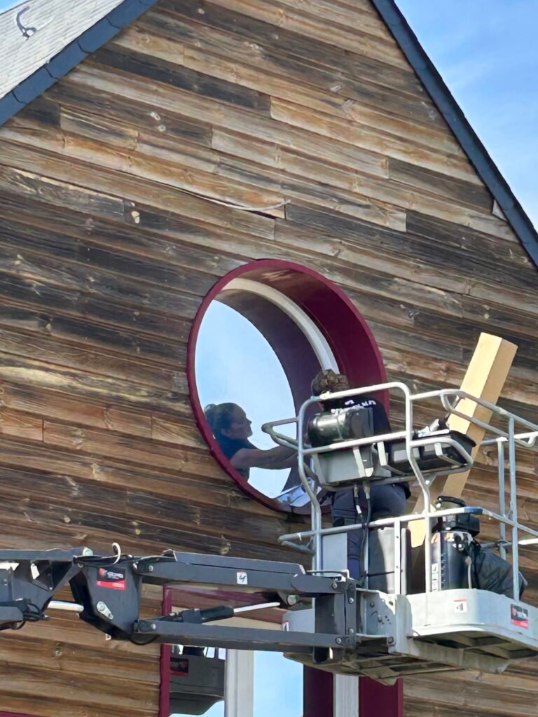 Vue depuis la nacelle sur un vitrage en hauteur et un oculus, école primaire du nord Sarthe